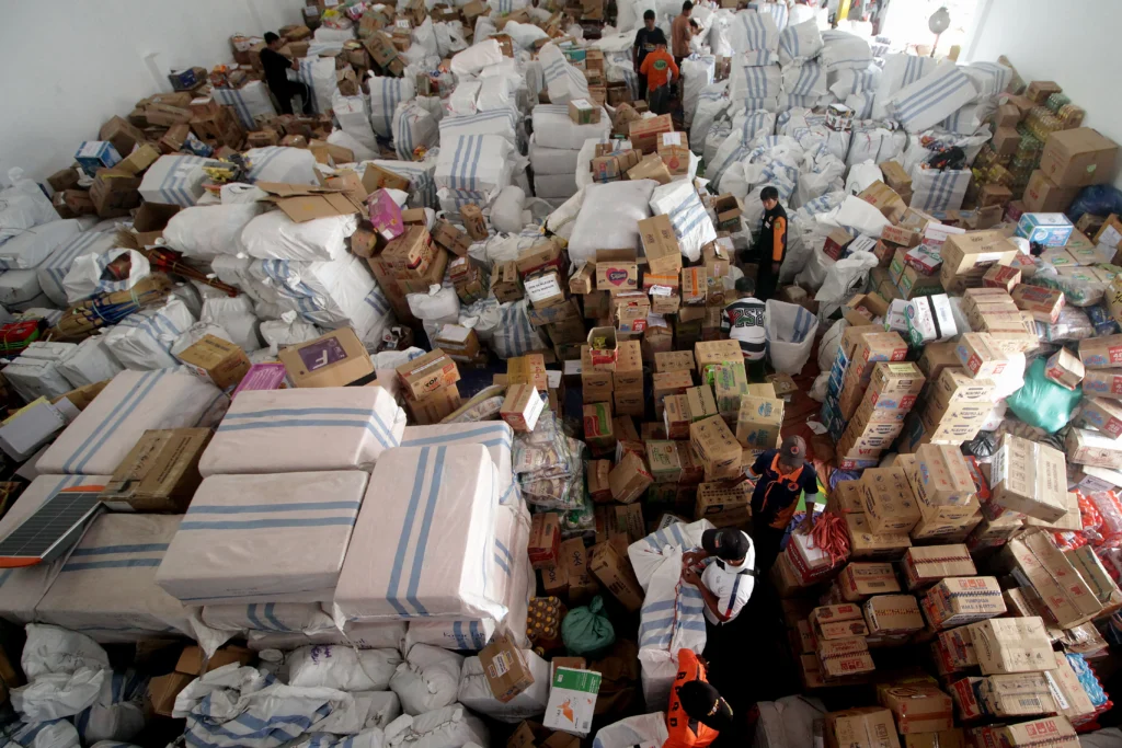 Petugas bersama relawan mengumpulkan berbagai jenis bantuan untuk korban bencana banjir bandang dan longsor di Sumatera Utara, Sumatera Barat, dan Aceh