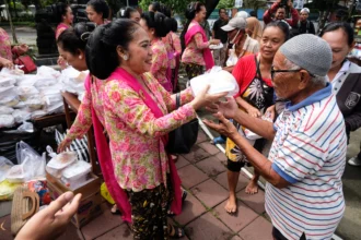 Sejumlah anggota komunitas Wanita Berkebaya Indonesia berbagi makanan kepada warga di kawasan Taman Monumen 45 Banjarsari, Solo, Jawa Tengah