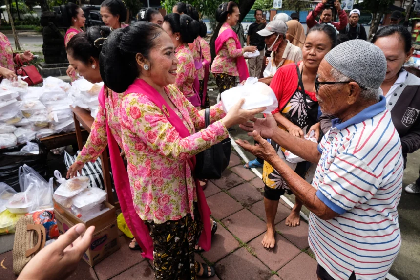 Sejumlah anggota komunitas Wanita Berkebaya Indonesia berbagi makanan kepada warga di kawasan Taman Monumen 45 Banjarsari, Solo, Jawa Tengah
