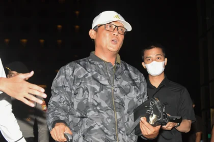 Bupati Lampung Tengah Ardito Wijaya (kiri) dikawal petugas saat tiba di Gedung Merah Putih KPK, Jakarta, Rabu (10/12/2025).