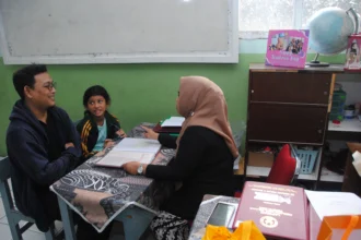 Guru berbincang dengan orang tua murid saat pembagian rapor di SDN Polisi 4, Kota Bogor, Jawa Barat