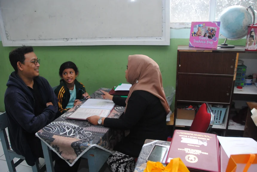 Guru berbincang dengan orang tua murid saat pembagian rapor di SDN Polisi 4, Kota Bogor, Jawa Barat
