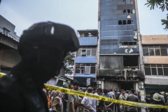 Petugas kepolisian berjaga di dekat gedung Terra Drone yang terbakar di jalan Letjen Soeprapto, Cempaka Baru, Kemayoran, Jakarta Pusat