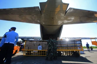 Petugas menurunkan bantuan logistik dari pesawat Hercules A-1315 saat tiba Pangkalan Lanud Sultan Iskandar Muda (SIM), kabupaten Aceh Besar, Aceh