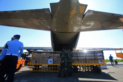 Petugas menurunkan bantuan logistik dari pesawat Hercules A-1315 saat tiba Pangkalan Lanud Sultan Iskandar Muda (SIM), kabupaten Aceh Besar, Aceh