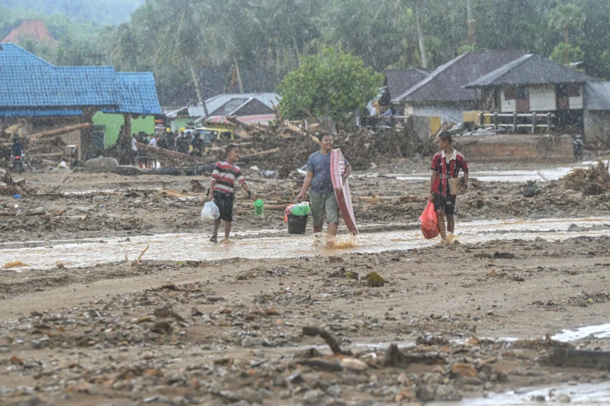 Warga korban bencana banjir dan tanah longsor membawa bantuan di Kelurahan Huta Nabolon, Kecamatan Tukka,Tapanuli Tengah, Sumatera Utara