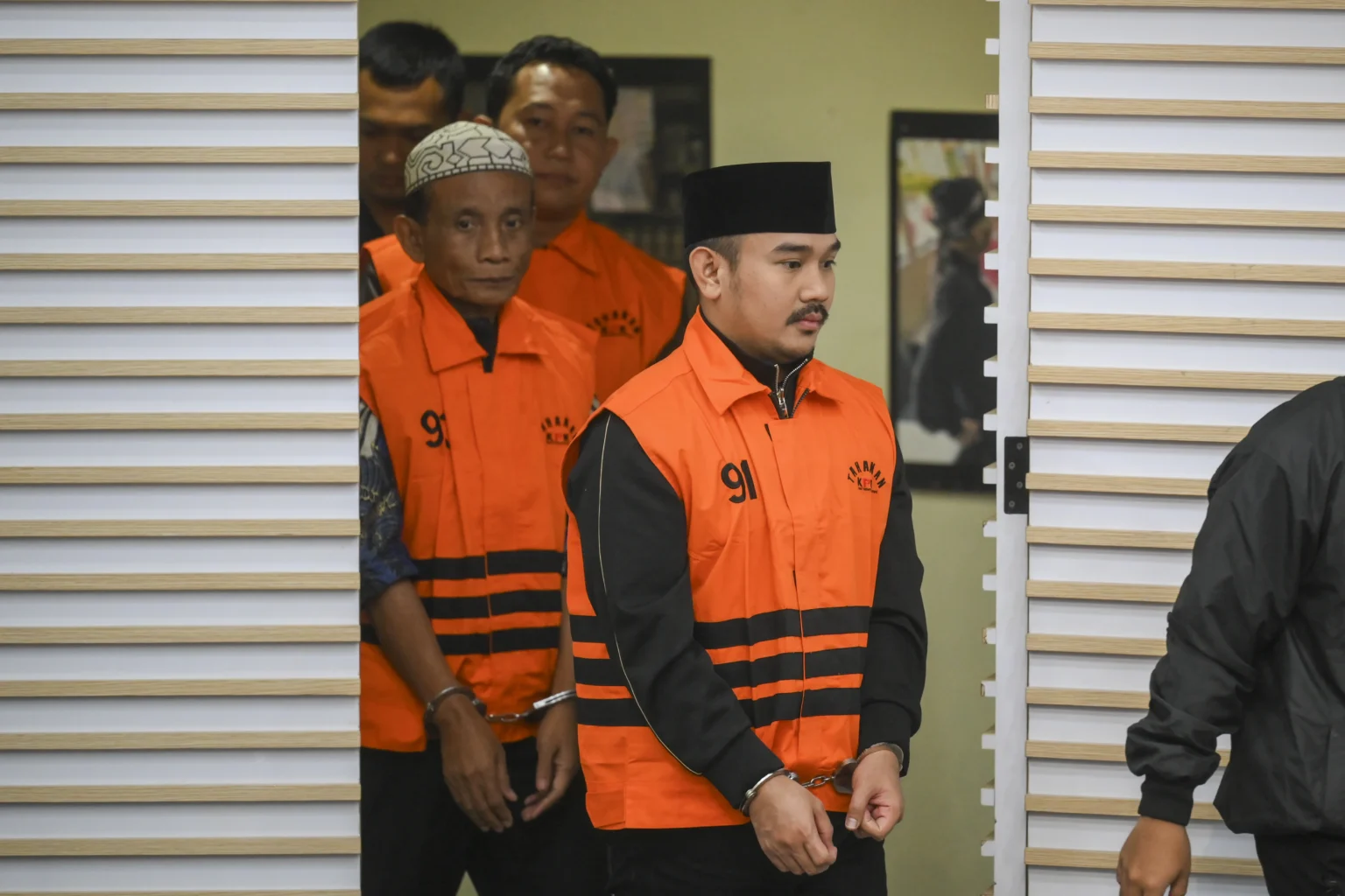 Bupati Bekasi Ade Kuswara Kunang bersama ayahnya H. M. Kunang (kiri) dan pihak swasta Sarjan (kedua kiri) dihadirkan saat konferensi pers penahanan usai terjaring operasi tangkap tangan (OTT) di Gedung Merah Putih KPK, Jakarta
