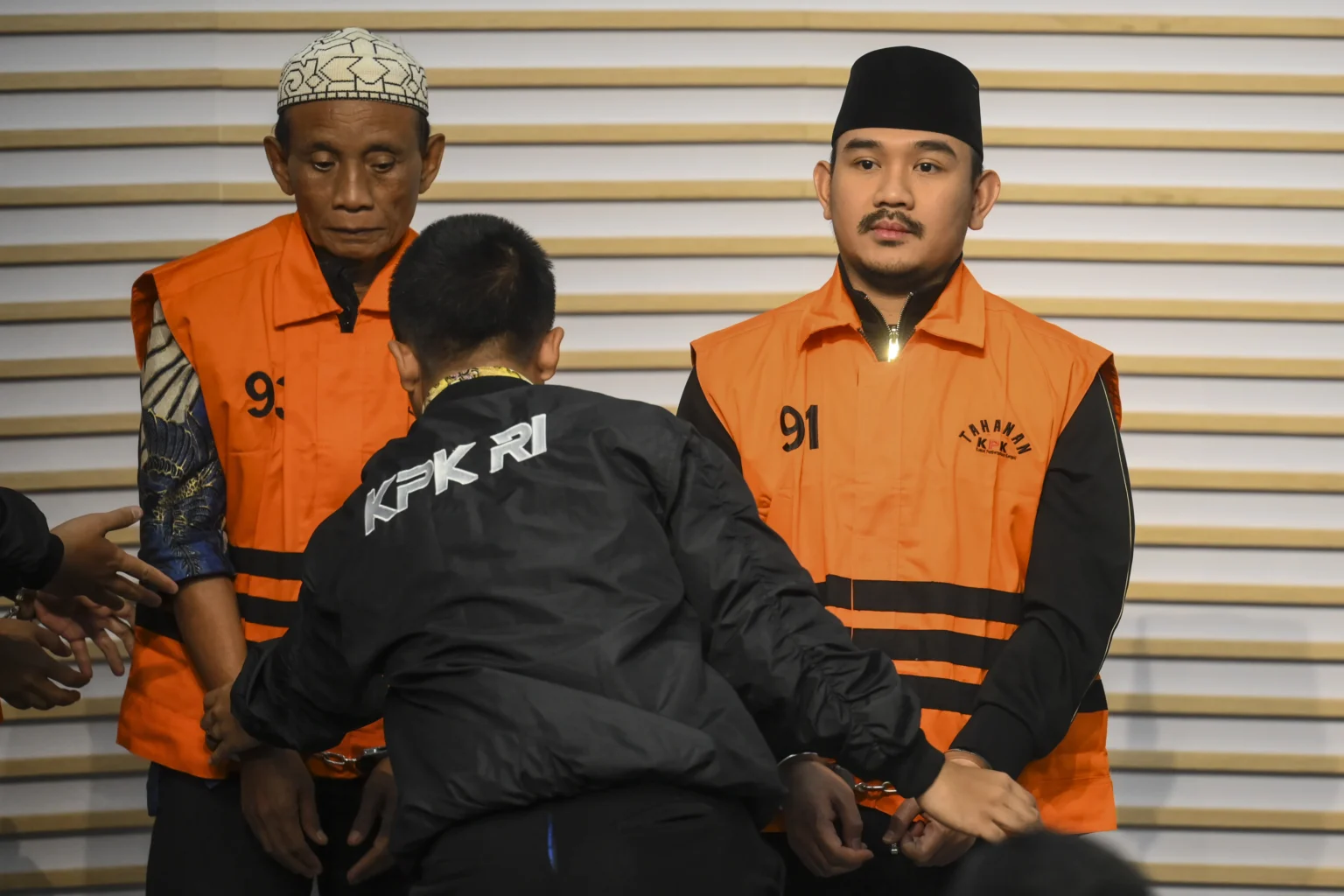 Bupati Bekasi Ade Kuswara Kunang (kanan) bersama ayahnya H. M. Kunang (kiri) dihadirkan saat konferensi pers penahanan usai terjaring operasi tangkap tangan (OTT) di Gedung Merah Putih KPK, Jakarta