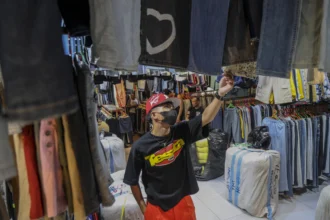 Seorang pengunjung memilih pakaian impor bekas