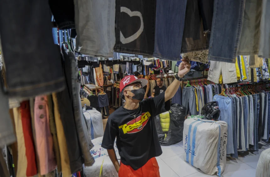 Seorang pengunjung memilih pakaian impor bekas
