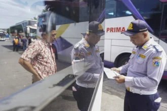 Petugas Dishub DKI Jakarta memeriksa kelengkapan dokumen bus saat uji kelaikan jalan di Terminal Kalideres, Jakarta