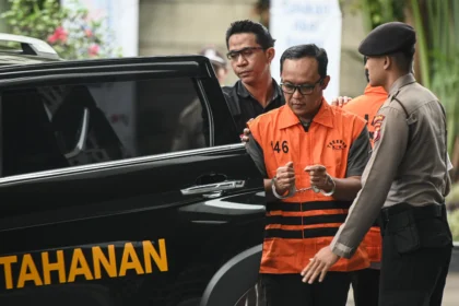 Tersangka kasus dugaan suap dan gratifikasi Bupati Lampung Tengah periode 2025-2030 Ardito Wijaya (tangah) keluar dari mobil tahanan menuju ruang konferensi pers di Gedung Merah Putih KPK, Jakarta, Kamis (11/12/2025).