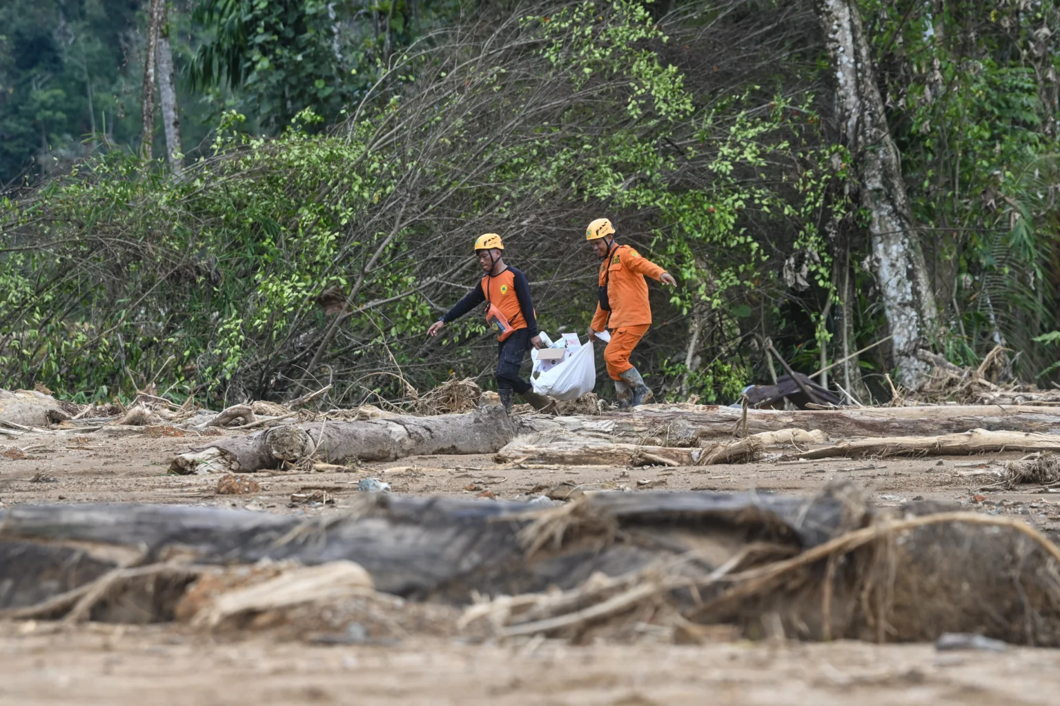 Anggota Basarnas gabungan berjalan membawa perlengkapan pencarian korban bencana tanah longsor dan banjir bandang di Kelurahan Sipange, Kecamatan Tukka,Tapanuli Tengah, Sumatera Utara, Selasa (9/12/2025)