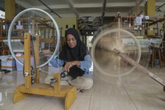 Pekerja memintal benang untuk pembuatan kain tenun puta dino di rumah Produksi Tenun Puta Dino Kayangan, Kota Tidore Kepulauan, Maluku Utara