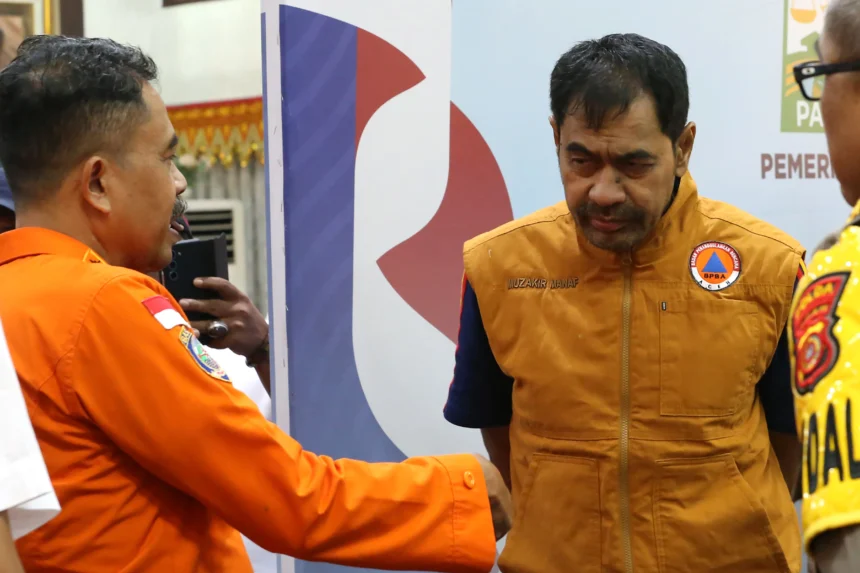 Gubernur Aceh Muzakir Manaf (kanan) berbincang dengan Deputi Bina Tenaga dan Potensi SAR Badan Nasional Pencarian dan Pertolongan (Basarnas) M Barokna Haulah (kiri) seusai menyampaikan pernyatan perpanjangan status tanggap darurat bencana hidrometeorologi di Banda Aceh