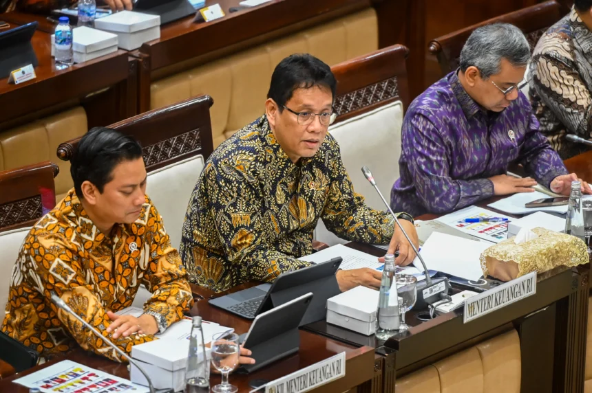 Menteri Keuangan Purbaya Yudhi Sadewa (tengah) didampingi Wakil Menteri Keuangan Thomas A. M. Djiwandono (kiri) dan Suahasil Nazara (kanan) menyampaikan paparan saat mengikuti rapat kerja dengan Komisi XI DPR di Kompleks Parlemen, Senayan, Jakarta, Kamis (27/11/2025)