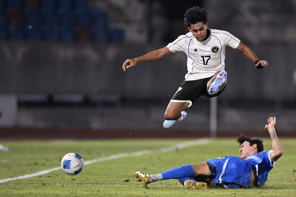 Pesepak bola Timnas Indonesia U-22 Rahmat Arjuna Reski (atas) berebut bola dengan pesepak bola Timnas Filipina Andres Rafael Aldeguer (bawah) pada pertandingan babak penyisihan Grup C Sepak Bola SEA Games 2025 di The 700th Anniversary of Chiang Mai Stadium, Chiang Mai, Thailand