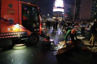 Tim Oranye membersihkan sisa sampah pada malam tahun baru di Bundaran HI