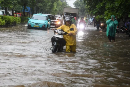 Warga mendorong motornya yang mogok saat melintasi banjir di kawasan Sunter, Jakarta, Senin (12/1/2026).