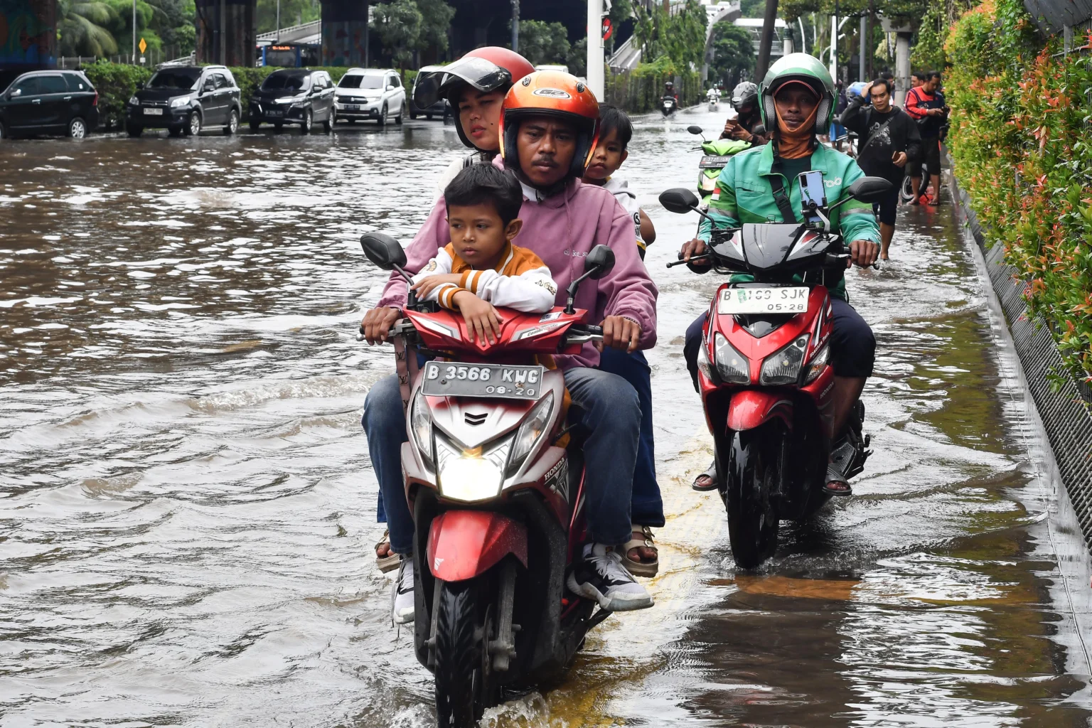 Pengendara sepeda motor melaju di atas trotoar saat banjir menggenangi Jalan Ahmad Yani, Cempaka Putih, Jakarta