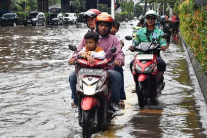 Pengendara sepeda motor melaju di atas trotoar saat banjir menggenangi Jalan Ahmad Yani, Cempaka Putih, Jakarta