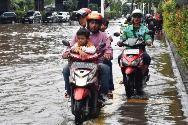 Ilustrasi, pengendara sepeda motor melaju di atas trotoar saat banjir menggenangi Jalan Ahmad Yani, Cempaka Putih, Jakarta