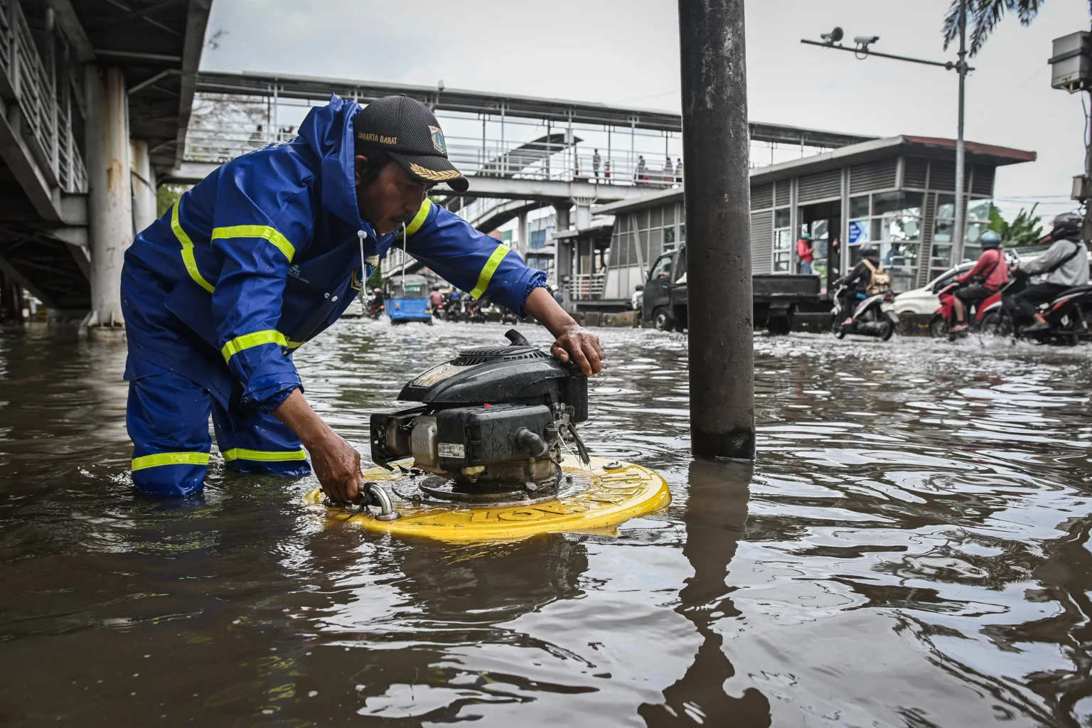 Petugas Dinas Sumber Daya Air DKI Jakarta mengoperasikan mesin pompa apung saat banjir di ruas Jalan Daan Mogot, Jakarta