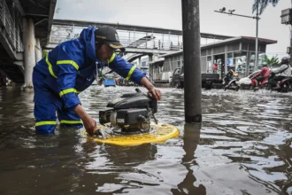 Petugas Dinas Sumber Daya Air DKI Jakarta mengoperasikan mesin pompa apung saat banjir di ruas Jalan Daan Mogot, Jakarta