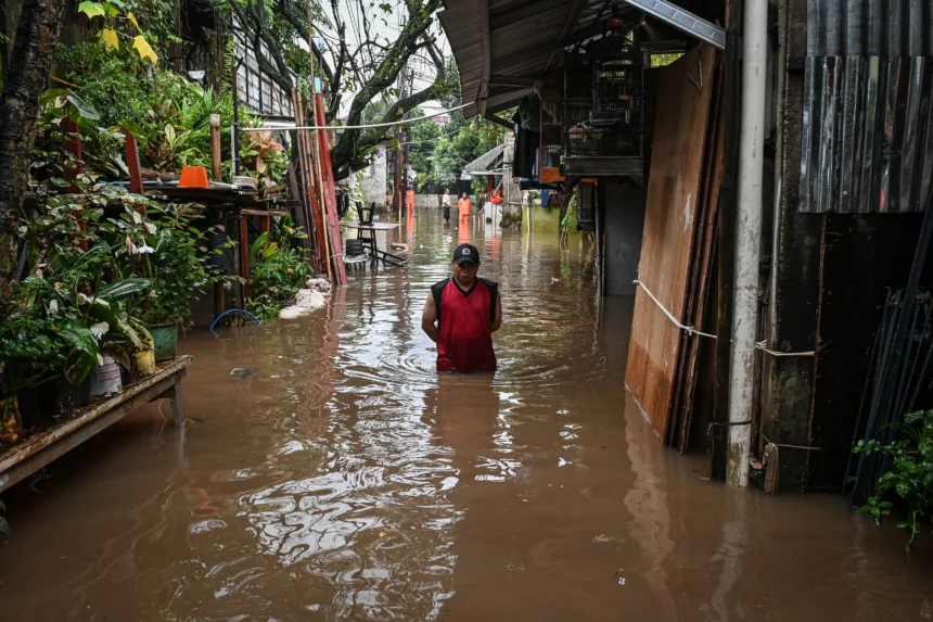 Warga berjalan menerobos banjir di kawasan Jalan NIS, Cilandak Timur, Jakarta