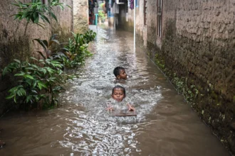 Anak-anak bermain saat banjir di kawasan Jalan NIS, Cilandak Timur, Jakarta