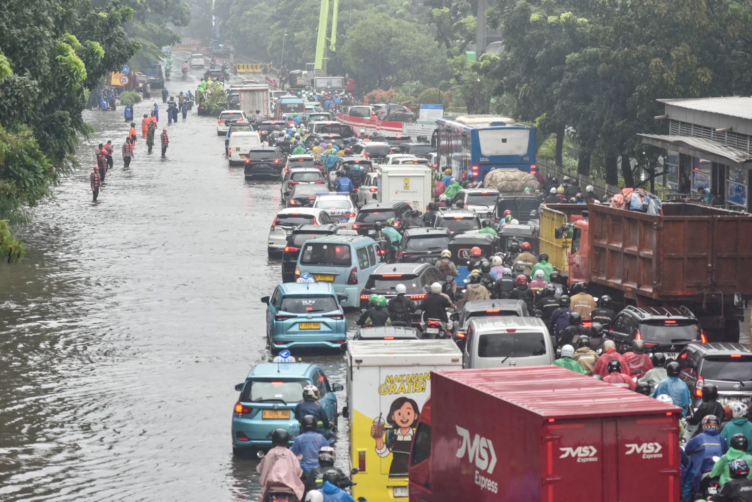 Antrean kendaraan melintasi jalan yang tergenang air di Cawang, Jakarta Timur, Kamis (22/1/2026). Curah hujan tinggi dan buruknya perawatan drainase menyebabkan genangan air merendam jalan DI Panjaitan dengan ketinggian 10-40 sentimeter