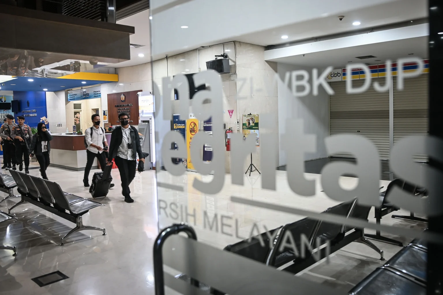 Petugas KPK membawa barang bukti usai melakukan penggeledahan di Kantor Pelayanan Pajak Madya Jakarta Utara, Jakarta, Senin (12/1/2026).