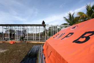 Prajurit TNI bersama petugas Badan Nasional Penanggulangan Bencana (BNPB) membangun hunian sementara (huntara) untuk korban bencana banjir bandang di Pidie Jaya, Aceh