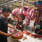 Pedagang memotong daging sapi dagangannya di Pasar Kebayoran Lama, Jakarta