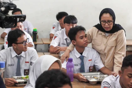 Wakil Kepala Badan Gizi Nasional (BGN) Nanik S Deyang (kanan) berbincang dengan siswa saat meninjau pelaksanaan program Makan Bergizi Gratis (MBG) di SMK Negeri 1 Jakarta
