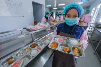 Relawan mengemas menu Makan Bergizi Gratis (MBG) di SPPG Polda Sultra, Kendari, Sulawesi Tenggara, Senin (19/1/2026).