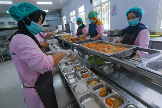 Relawan mengemas menu Makan Bergizi Gratis (MBG) di SPPG Polda Sultra, Kendari, Sulawesi Tenggara.