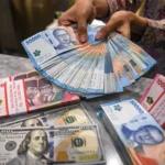Petugas menunjukkan pecahan mata uang Rupiah dan Dolar Amerika Serikat (AS) di Kantor Cabang BNI Pasar Baru, Jakarta