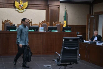 Tersangka kasus dugaan korupsi dalam digitalisasi pendidikan pengadaan laptop Chromebook di Kemendikbudristek tahun 2019-2022 Nadiem Makarim (kiri) bersiap mengikuti sidang pembacaan dakwaan di Pengadilan Tipikor, Jakarta