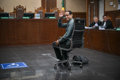 Nadiem Makarim melambaikan tangan ke arah wartawan sebelum sidang pembacaan dakwaan di Pengadilan Tipikor, Jakarta, Senin (5/1/2026).