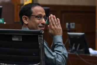 Nadiem Makarim memberikan salam ke arah wartawan sebelum sidang pembacaan dakwaan di Pengadilan Tipikor, Jakarta, Senin (5/1/2026)