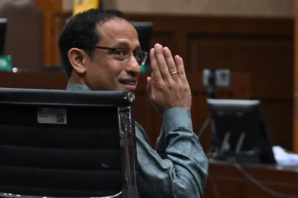 Nadiem Makarim memberikan salam ke arah wartawan sebelum sidang pembacaan dakwaan di Pengadilan Tipikor, Jakarta, Senin (5/1/2026)