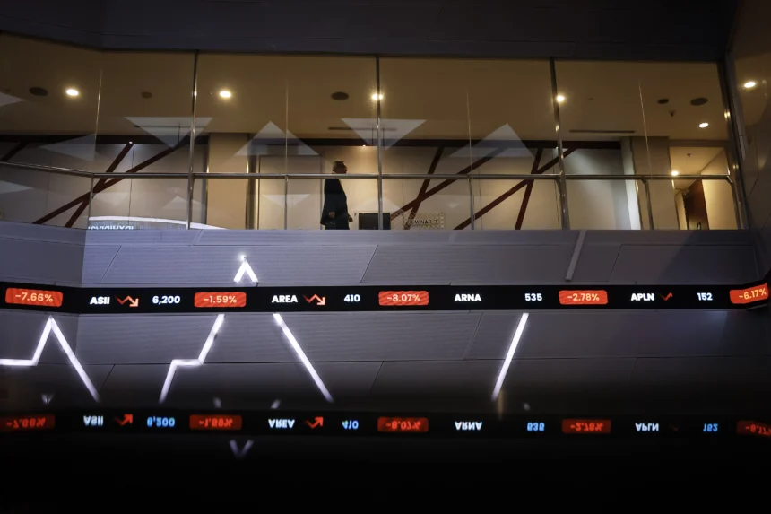 Seorang pria berjalan di atas layar digital pergerakan Indeks Harga Saham Gabungan (IHSG) di Bursa Efek Indonesia (BEI), Jakarta, Rabu (28/1/2026).