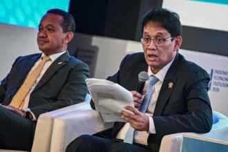 Menteri Keuangan Purbaya Yudhi Sadewa (kanan) dan Menteri ESDM Bahlil Lahadalia (kiri) menyampaikan paparannya saat diskusi panel Indonesia Economic Outlook 2026 di Wisma Danantara, Jakarta