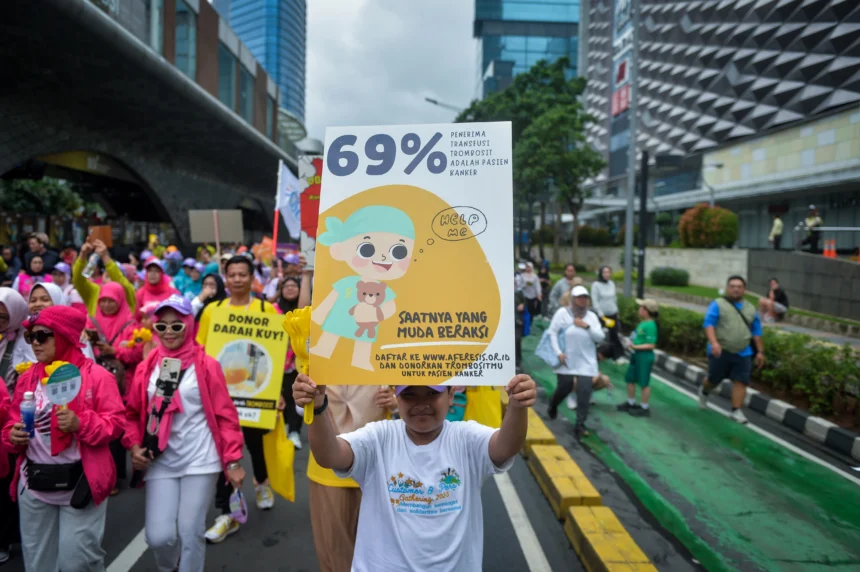 Warga membawa poster saat kampanye peringatan Hari Kanker Sedunia pada Hari Bebas Kendaraan Bermotor (HBKB) di kawasan Bundaran HI, Jakarta