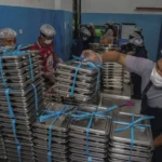 Petugas menyusun ompreng berisi Makan Bergizi Gratis (MBG) di dapur SPPG Tubo Ternate, Maluku Utara