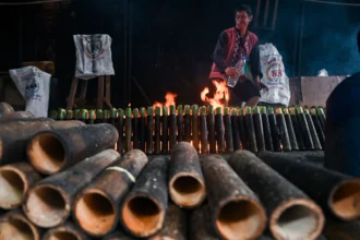 Pekerja menyelesaikan proses pembakaran lemang bambu di daerah Senen, Jakarta