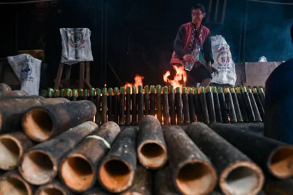Pekerja menyelesaikan proses pembakaran lemang bambu di daerah Senen, Jakarta