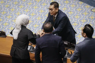 Hakim Mahkamah Konstitusi (MK) usulan DPR Adies Kadir (tengah) menerima ucapan selamat dari anggota DPR saat mengikuti Rapat Paripurna DPR ke-12 Masa Persidangan III Tahun Sidang 2025-2026 di Kompleks Parlemen, Senayan, Jakarta