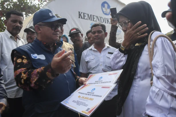Menteri Pendidikan Dasar dan Menengah (Mendikdasmen) Abdul Mu'ti (kedua kiri) berbincang dengan Kepala Sekolah SD Negeri 9 Tanah Jambo Aye Suryani (kanan) saat meninjau aktivitas belajar mengajar di tenda darurat di Desa Lueng Tuha, Kecamatan Tanah Jambo Aye, Aceh Utara, Aceh